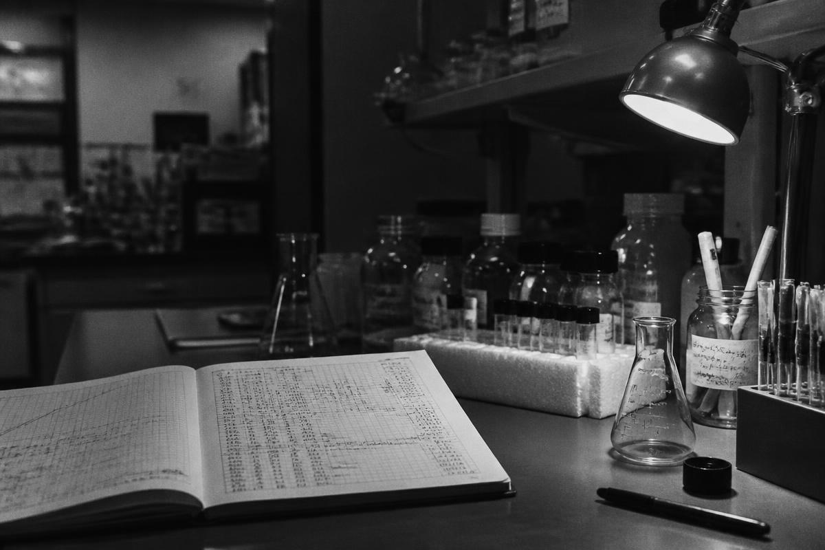 Laboratory bench with a handwritten results notebook under a lamp